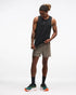 hoka everyrun tank top for men, light breathable running singlet , black colour with silver reflective HOKA logo, full body profile of a man wearing hoka tank with taupe shorts