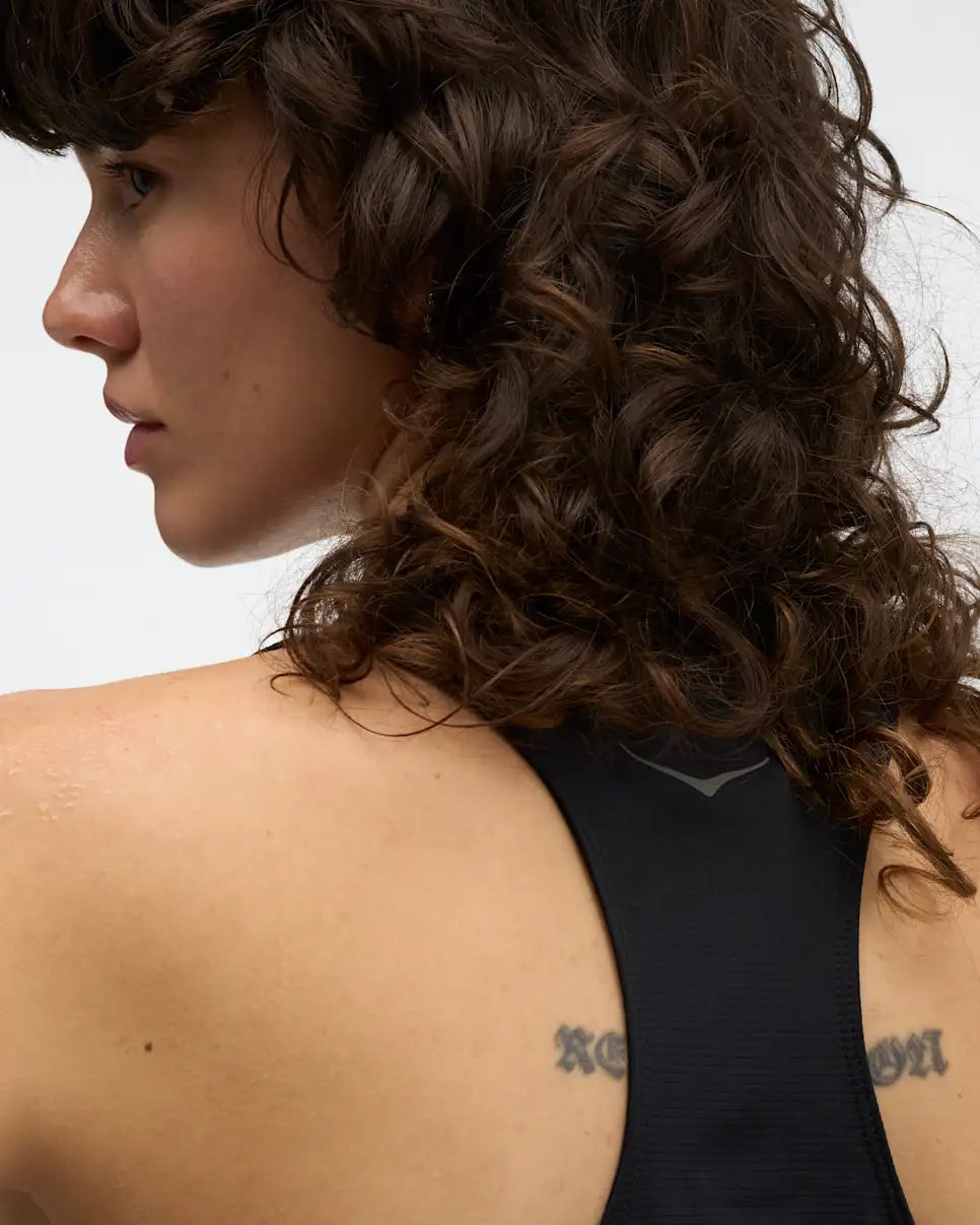 hoka everyrun womens tank in black. The  ultralight tank is tuned for daily training with comfort-first design details. Cut from our breathable, quick-dry FlyLite™ material, the slim-fit silhouette wicks sweat to keep you dry from first mile to last.