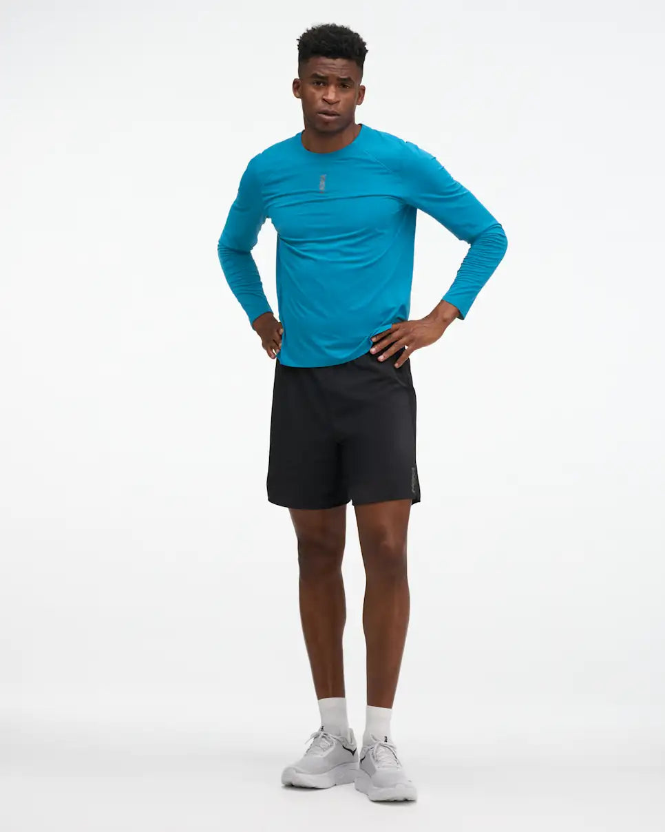 HOKA Glide 7'' Short 2-in-1, lightweight running short with inner short, black colour, man wearing black shorts with long sleeve blue shirt and white shoes