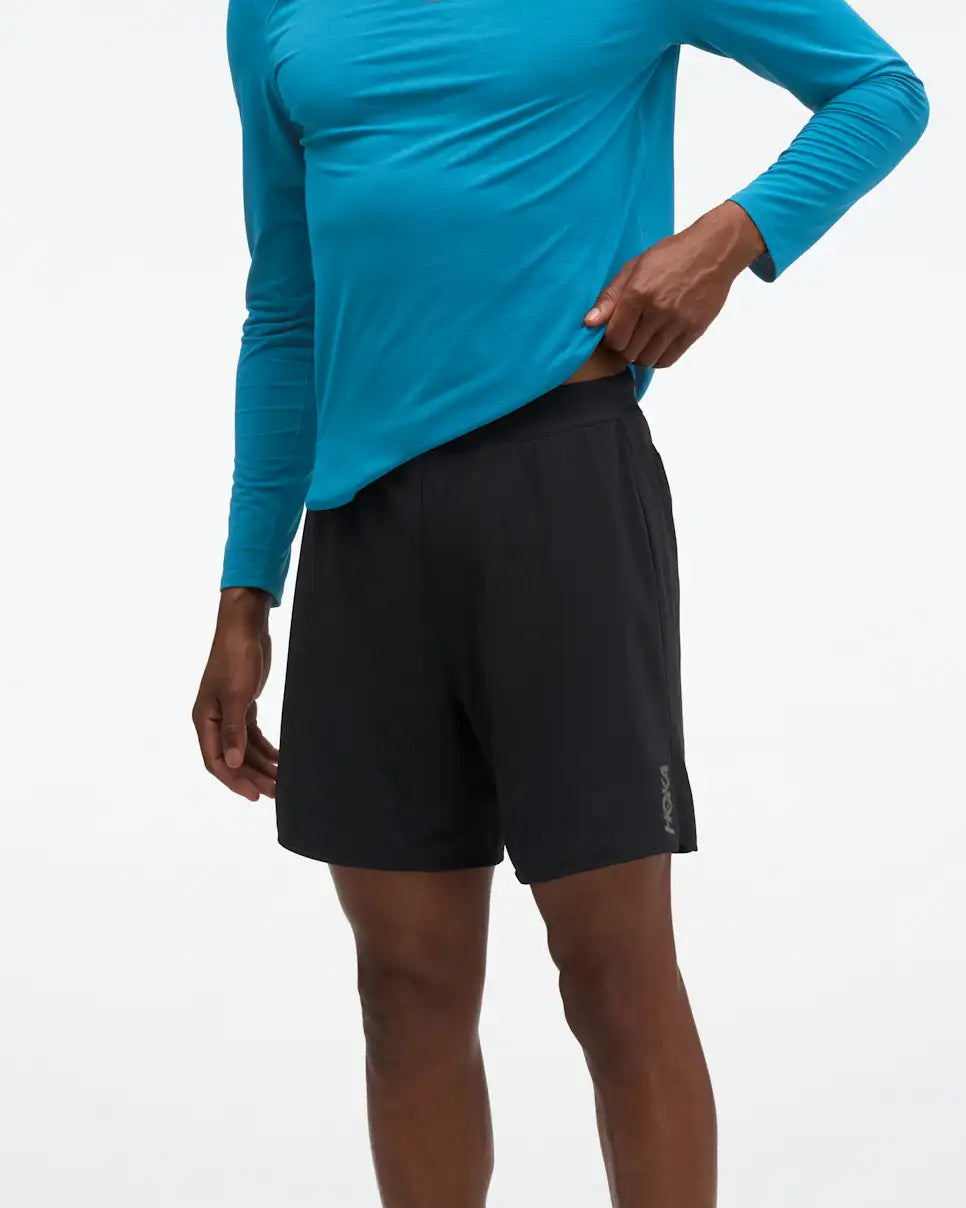 HOKA Glide 7'' Short 2-in-1, lightweight running short with inner short, black colour, man wearing shorts with long sleeve blue shirt