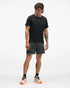 hoka 5" glide short with internal brief, black colour with white swirl pattern, full body shot of a man wearing hoka shorts with a black t-shirt on a white background