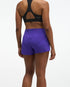 Hoka glide short mr 3.5", sweat wicking trail and road running shorts with pockets, purple shorts, back of woman wearing black sports bra with purple shorts
