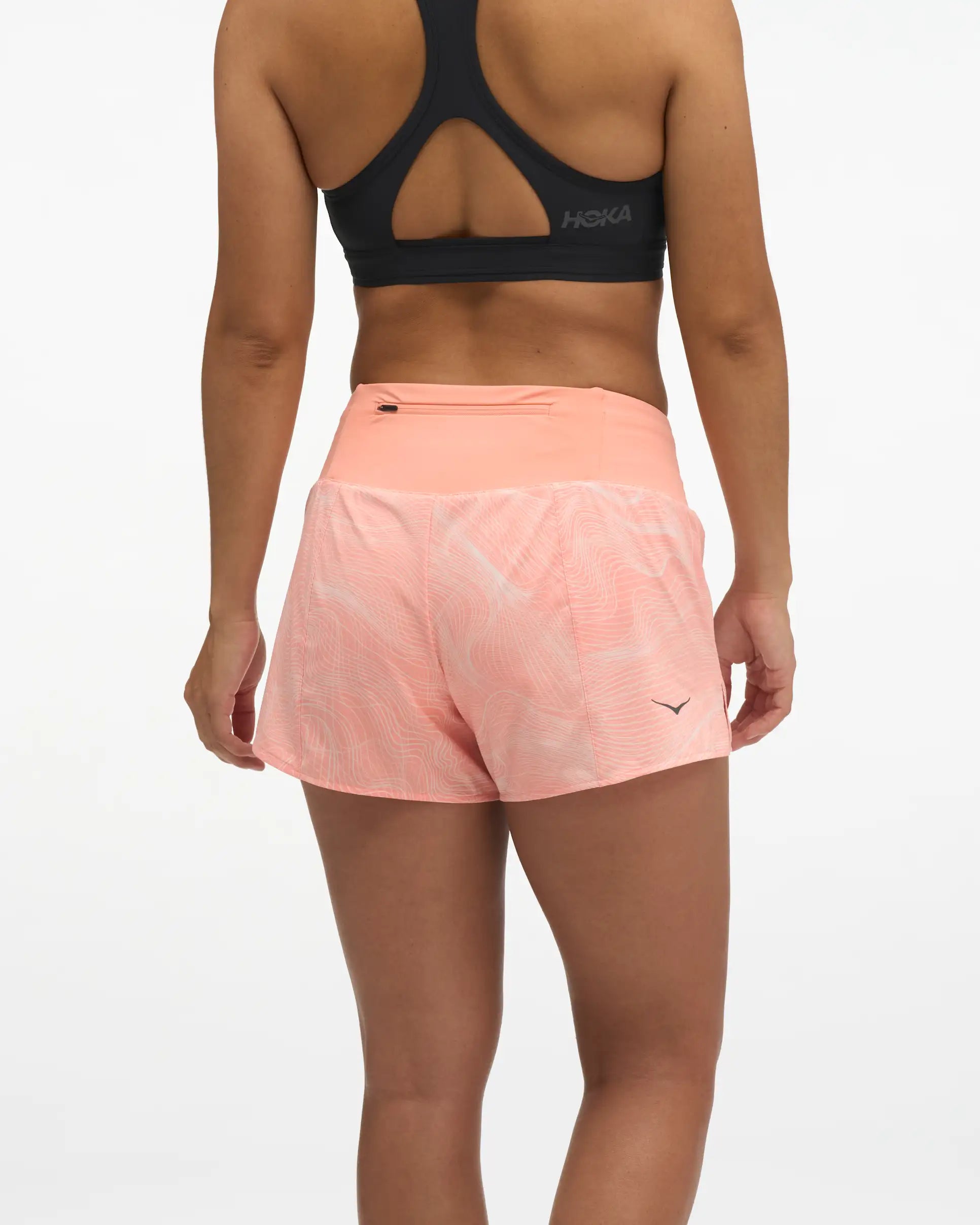 Hoka glide short mr 3.5", sweat wicking trail and road running shorts with pockets, light peach coloured shorts, woman wearing black sports bra with light peach shorts
