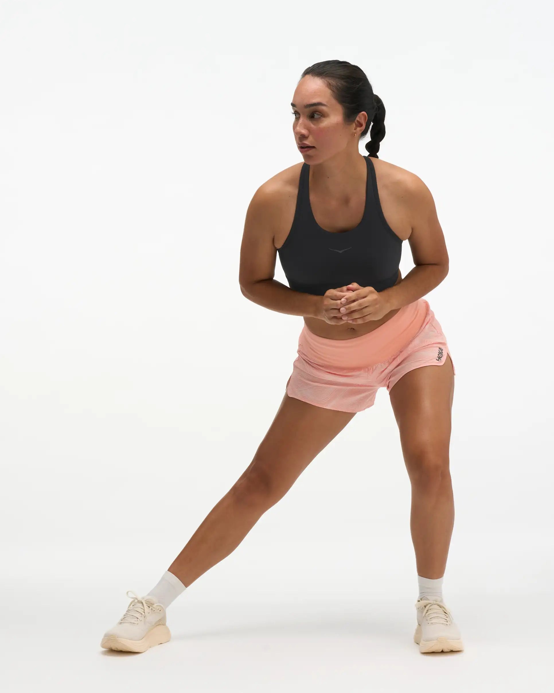 Hoka glide short mr 3.5", sweat wicking trail and road running shorts with pockets, light peach coloured shorts, woman wearing black sports bra with light peach shorts