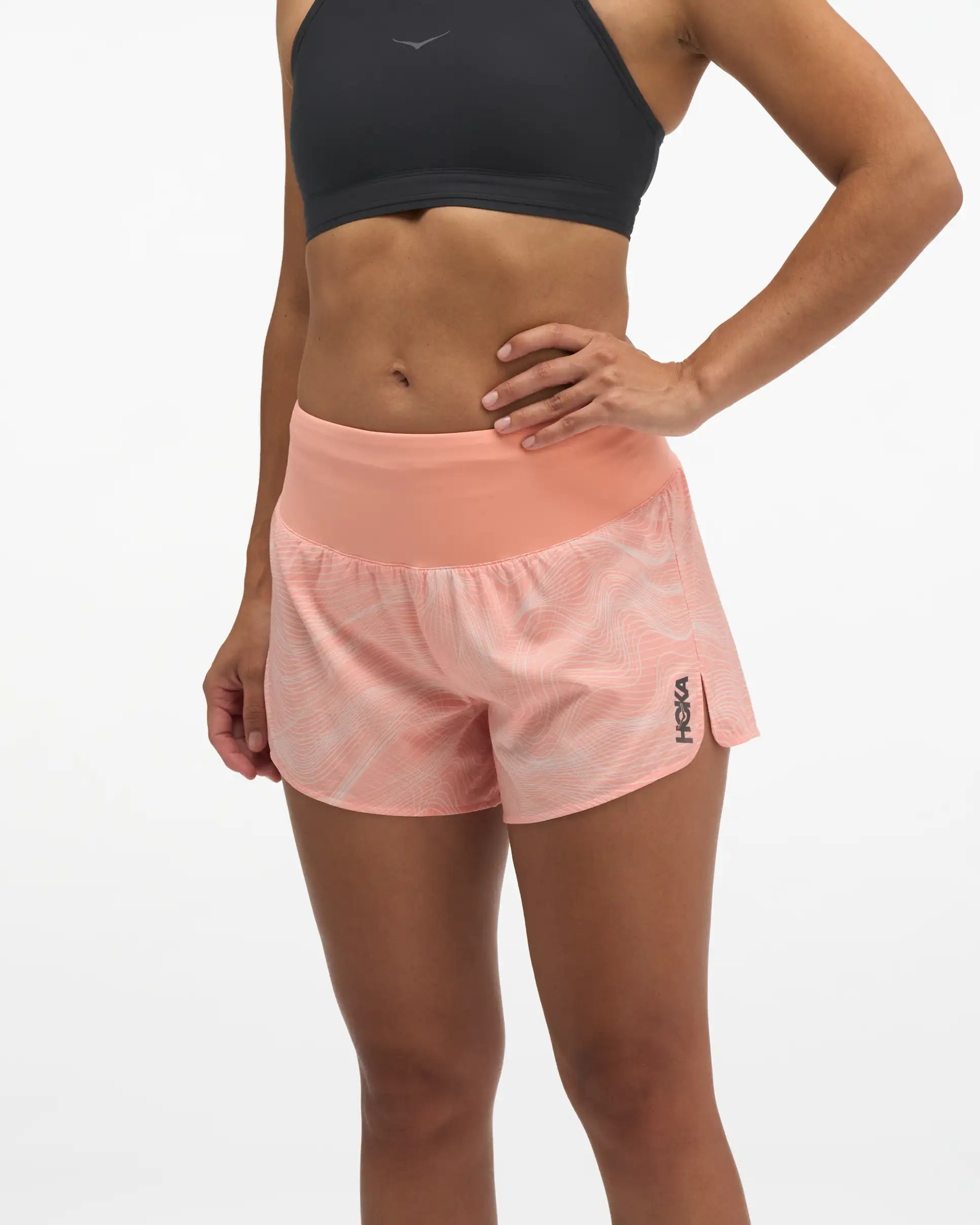 Hoka glide short mr 3.5", sweat wicking trail and road running shorts with pockets, light peach coloured shorts, woman wearing black sports bra with light peach shorts