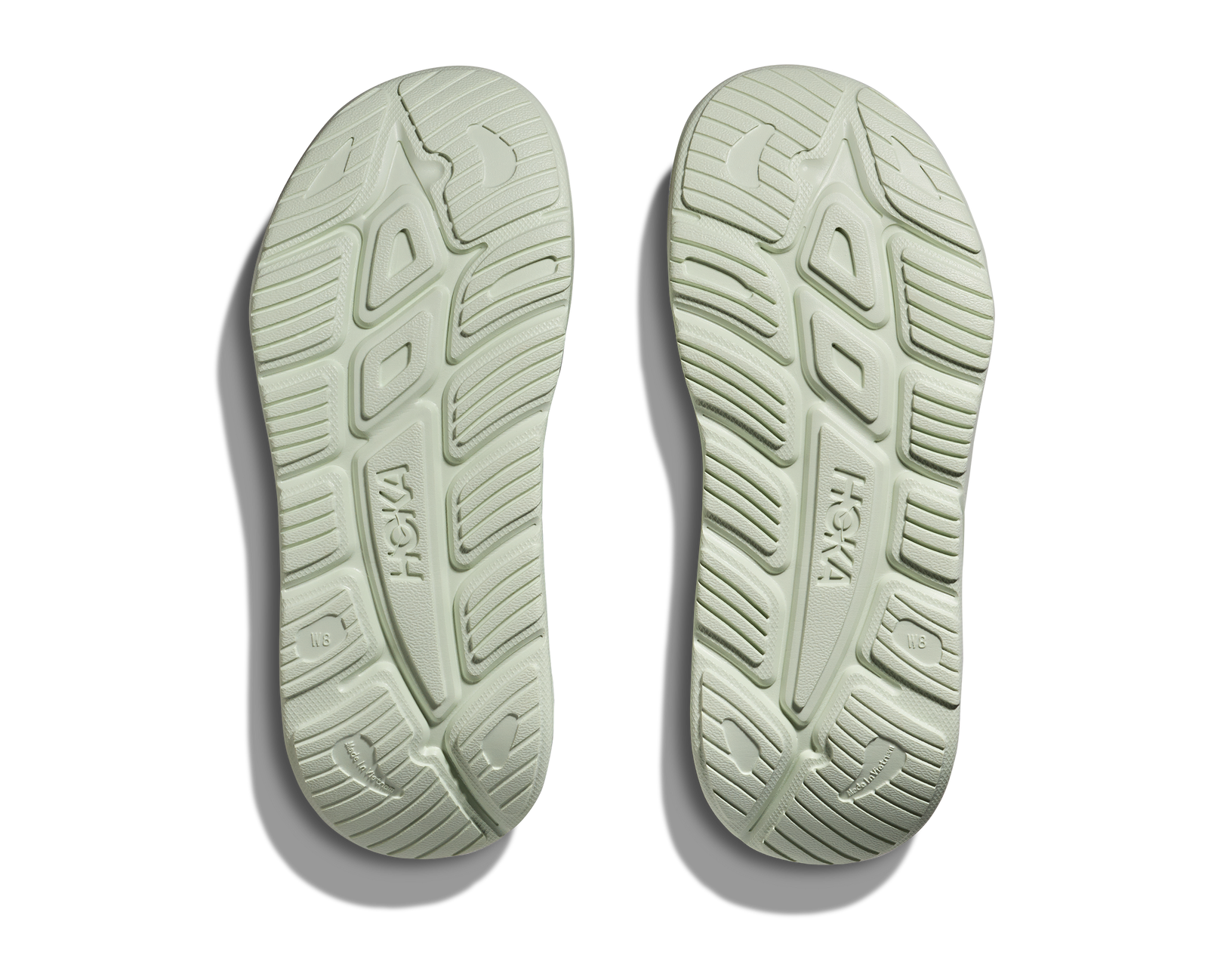 hoka ora recovery slide for all gender, comfortable and supportive slider for after run recovery, light green colour, bottom profile of sole of ora slide on a white background
