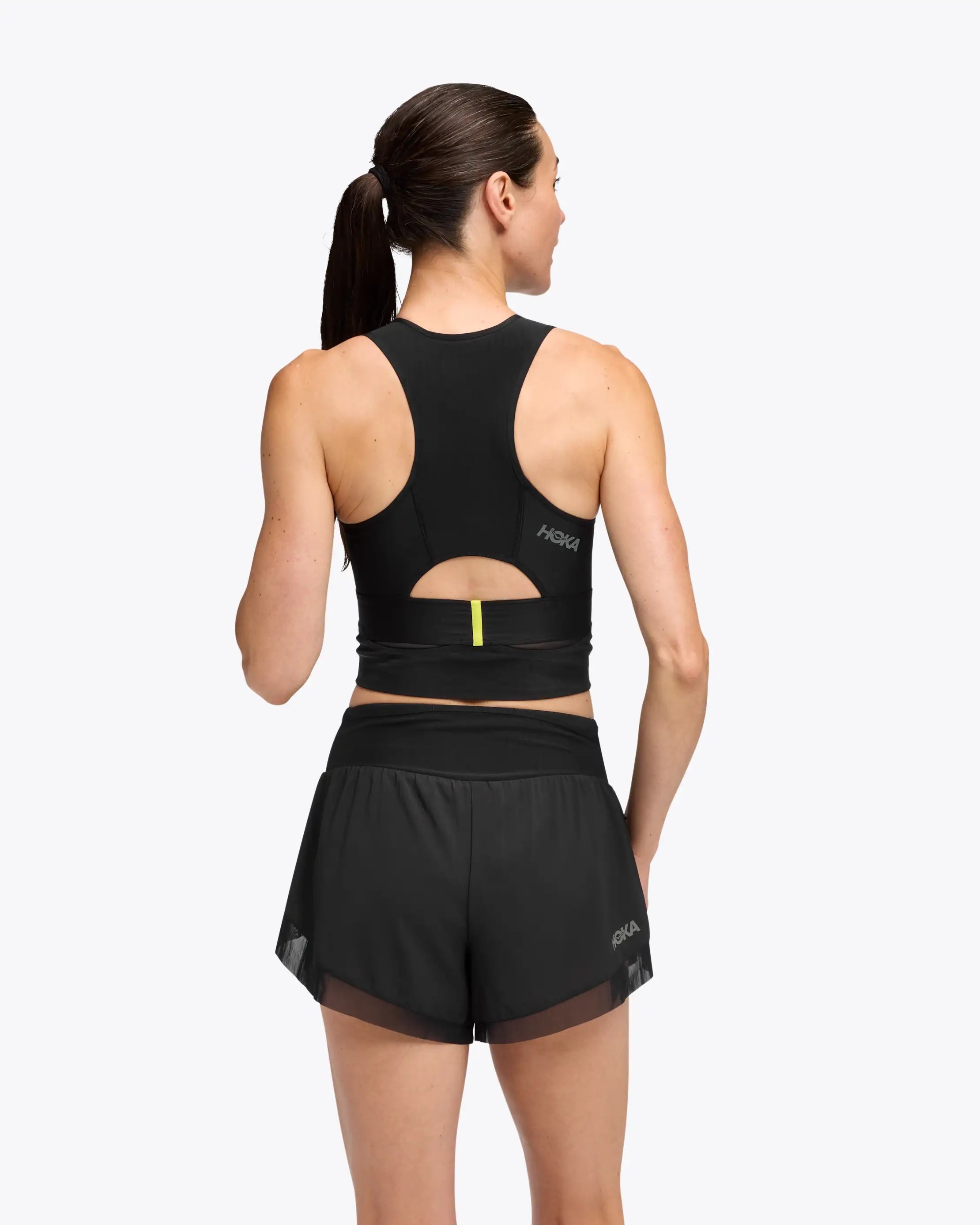 hoka race day bra, black crop top for warm weather running, back cut out of running crop top woman wearing 