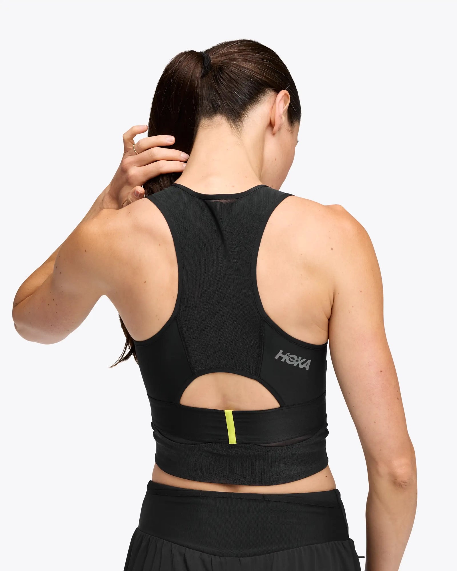hoka race day bra, black crop top for warm weather running, up lose of back of bra with yellow stripe detail