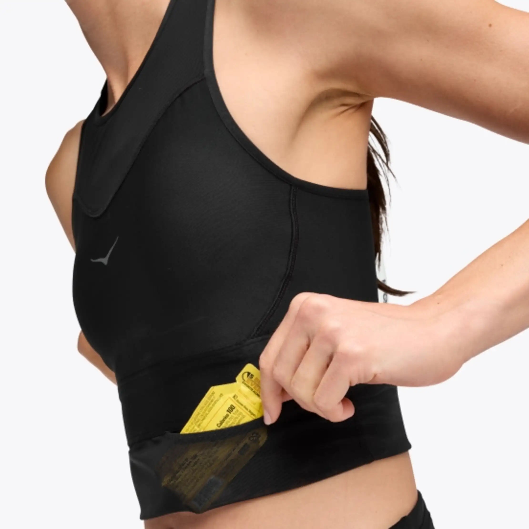 hoka race day bra, black crop top for warm weather running, close up of mesh pocket under front chest of bra