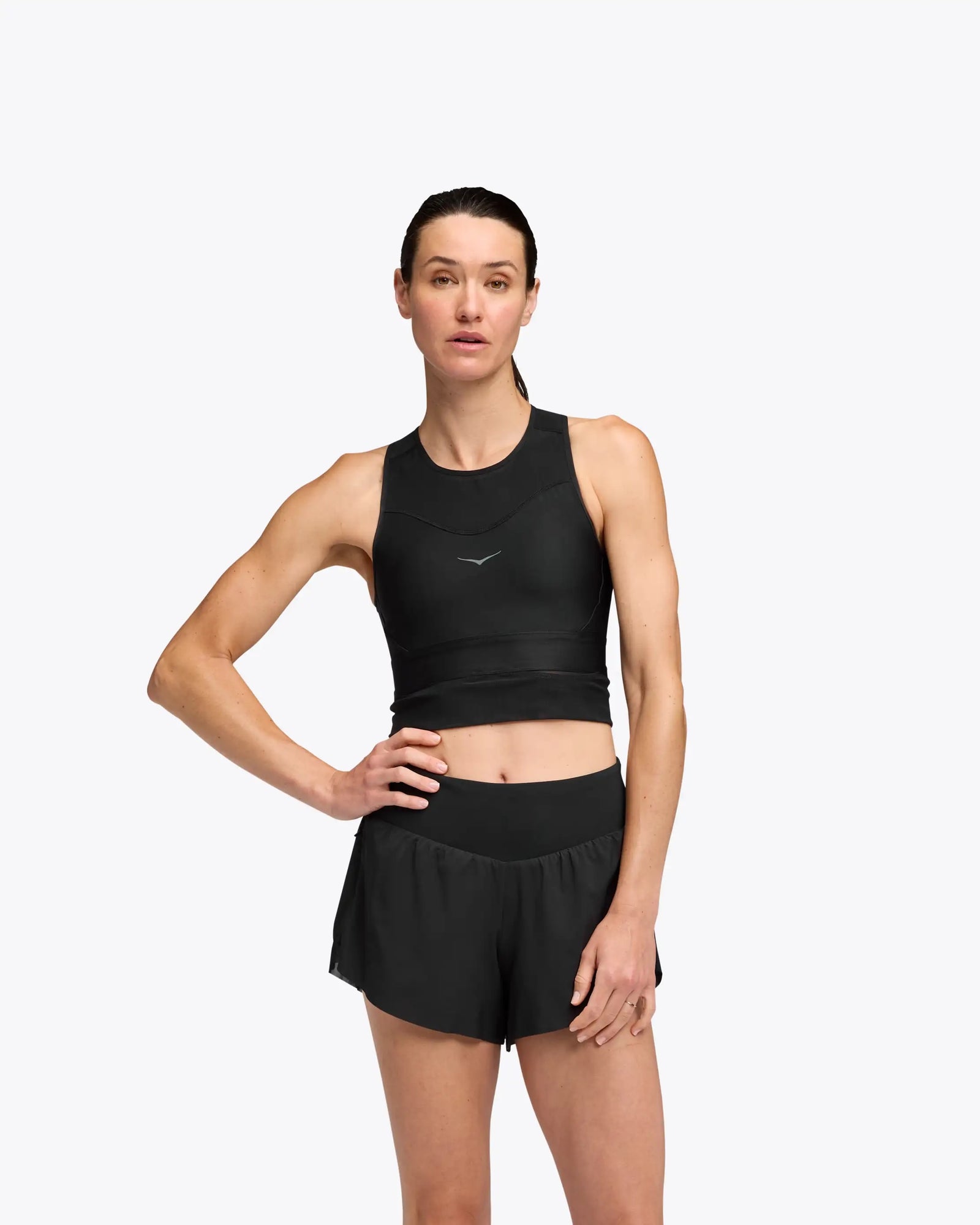 hoka race day bra, black crop top for warm weather running, woman wearing hoka sports bra top with black shorts