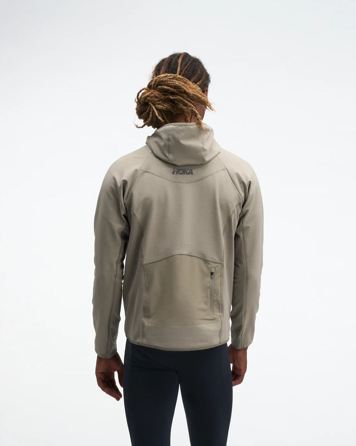 hoka men's skyglow half zip running top,  water resistant, stretchy long-sleeve pull over with a hood, light grey colour, back view of model wearing half-zip with black trousers on a white background