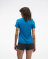 hoka everyrun short sleeve running t-shirt for women, blue colour with silver reflective logo, woman wearing hoka tee with black shorts on a white background