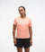 hoka everyrun short sleeve running t-shirt for women, peach colour with silver reflective logo, front view of woman wearing hoka tee with black shorts on a white background
