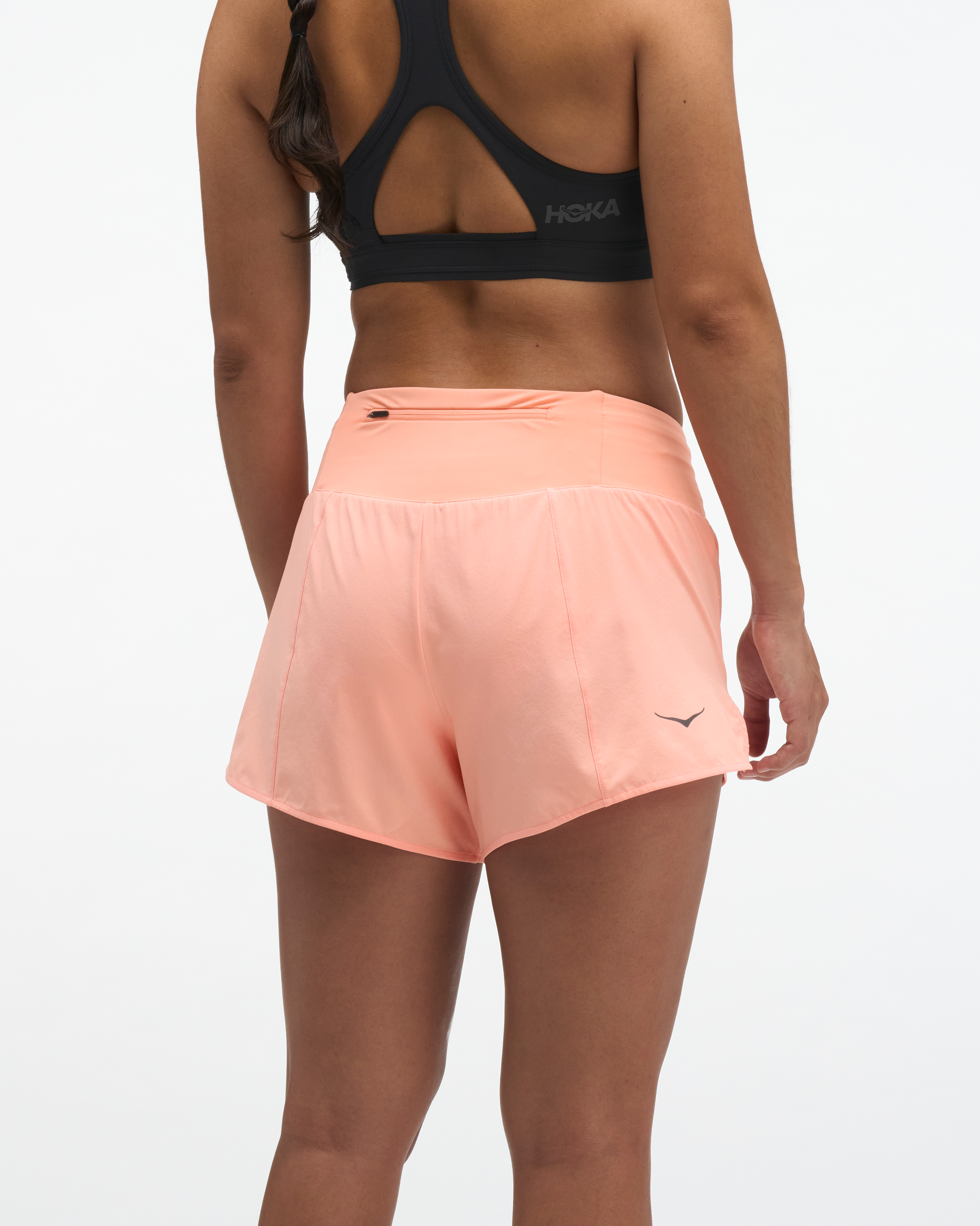 hoka womens glide short mr 3.5 brief, lightweight running short, solid peach colour, back of women wearing running shorts 
