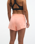 hoka womens glide short mr 3.5 brief, lightweight running short, solid peach colour, back of women wearing running shorts 