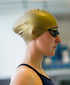woman wearing a gold swim cap with the sage green huub eternal swim goggles side profile of head