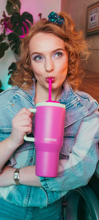 kambukka rio tumbler, 950 ml water bottler with handle and collapsable straw, pink colour with mint green accents, women drinking out of pink tumbler 