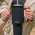 kambukka rio tumbler, 950 ml water bottler with handle and collapsable straw, black colour, person holding tumbler water bottle