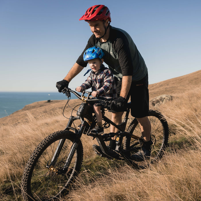 Kids Ride Shotgun 2.0 Child Bike Seat + Handlebars Combo, man riding bike with child through long dry grass