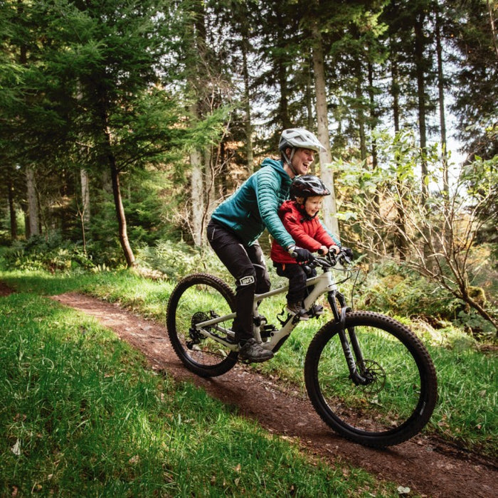 Kids Ride Shotgun Child Bike Seat + Handlebars Combo, woman and child riding bike through forest terrain 