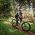 Kids Ride Shotgun Child Bike Seat + Handlebars Combo, woman and child riding bike through forest terrain 