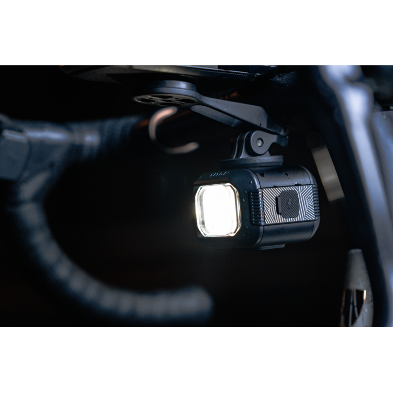 moon titan max bike light, small square bike light under handlebars, light turned on with dark background