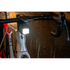 moon titan max bike light, small square bike ligt under front handlebars of bike, light turned on in dark rain