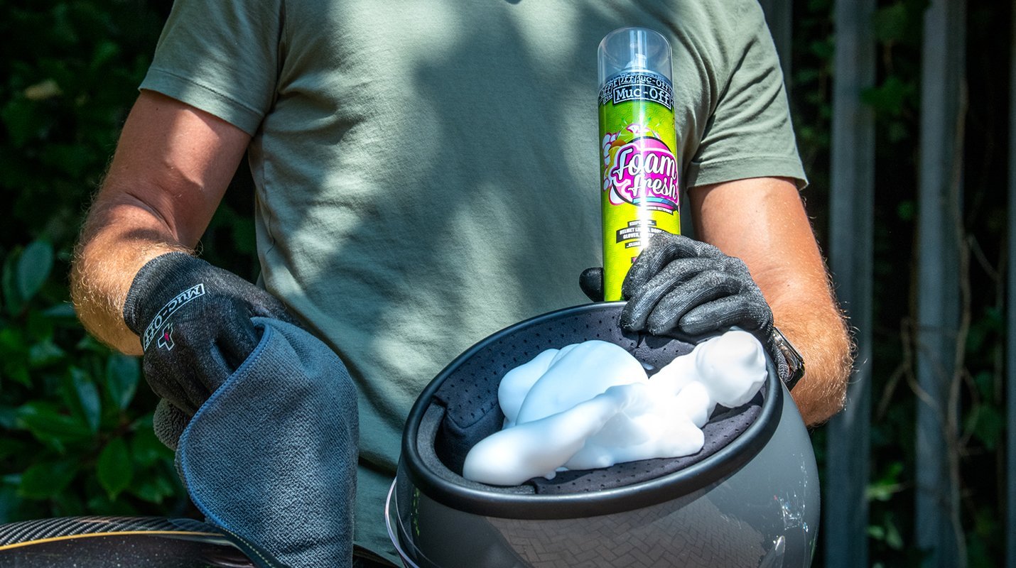 muc off foam fresh cleaning spray foam, white foam inside helmet with person in background 