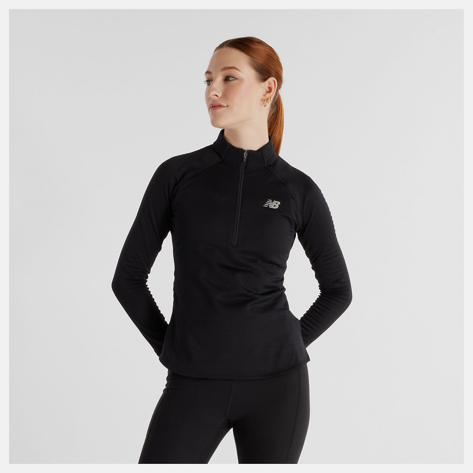 Woman wearing a black New Balance long-sleeve athletic top 