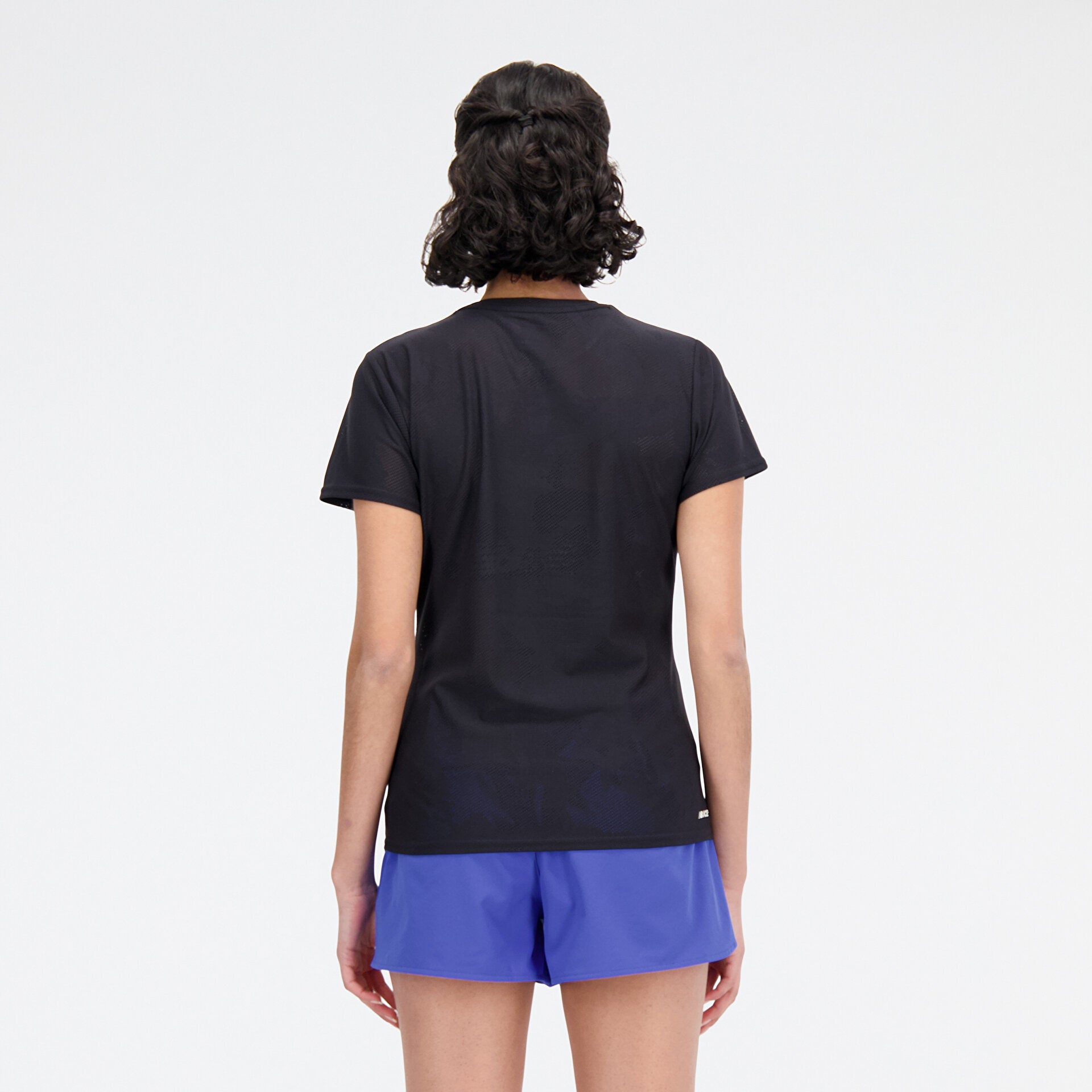 Woman wearing new balance jacquard short sleeve tee in black, back