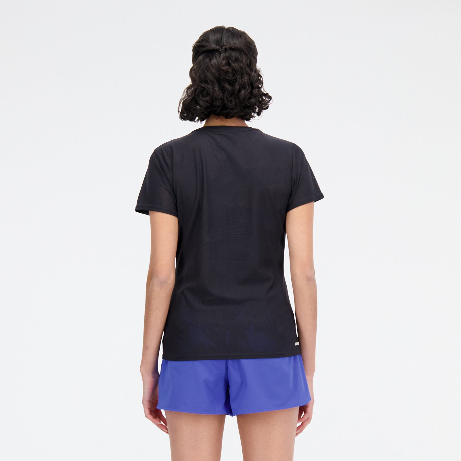 Woman wearing new balance jacquard short sleeve tee in black, back