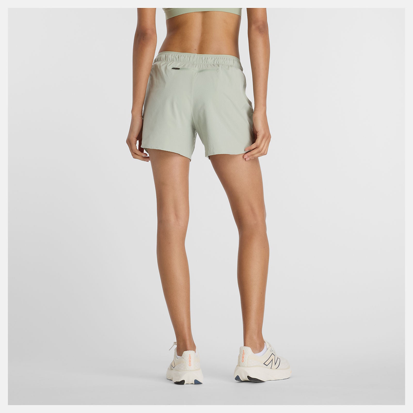 Woman wearing new balance 5 inch rc short in light green colour