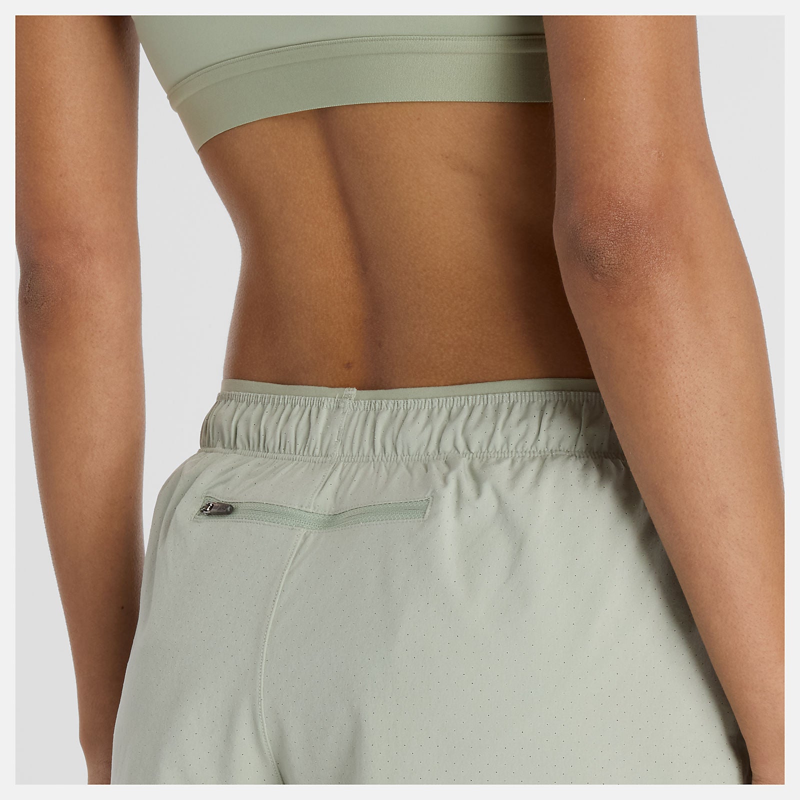 Woman wearing new balance 5 inch rc short in light green colour
