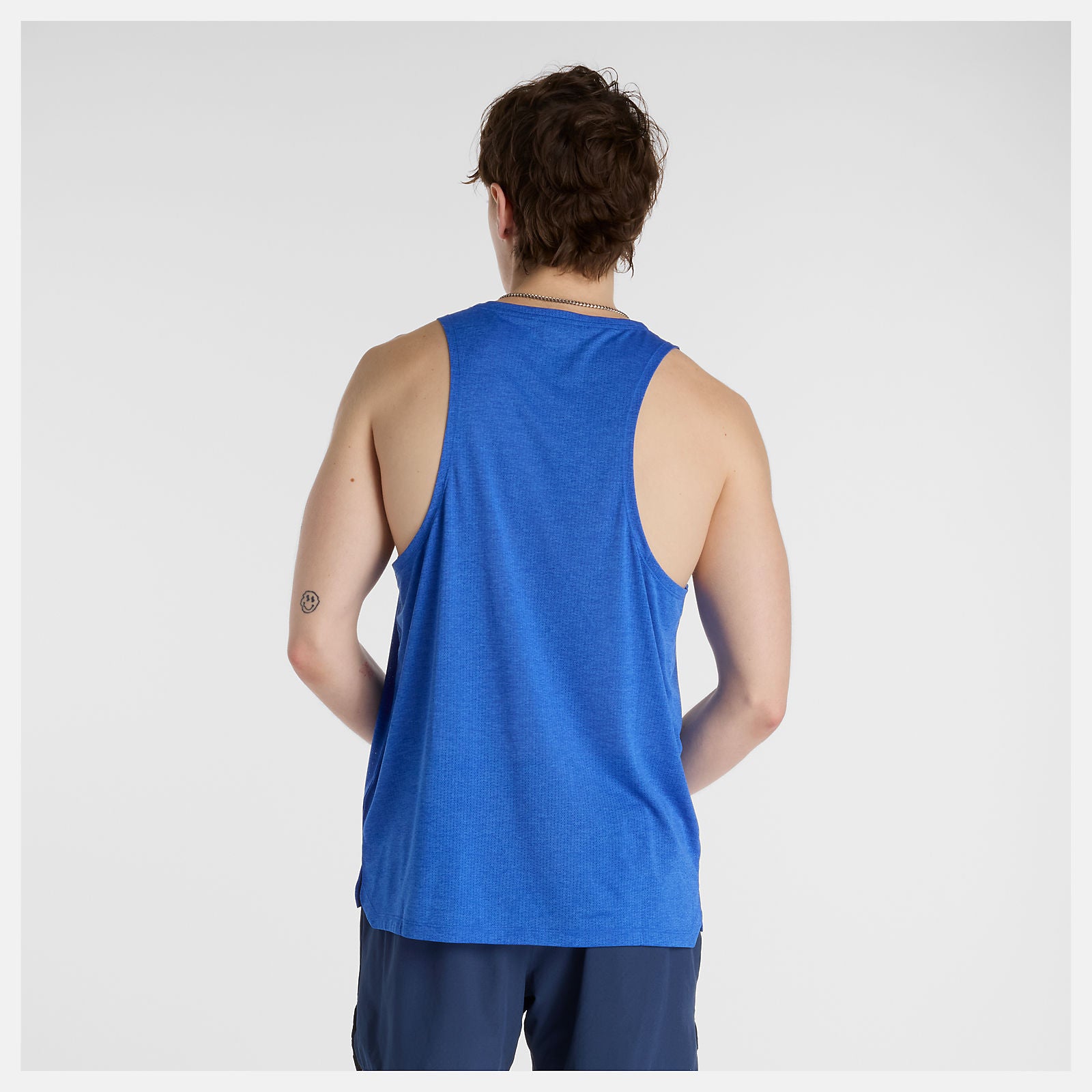 Man wearing a nb run tank in blue and shorts on a white background