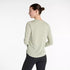 new balance athletics long sleeve, long sleeve breathable layering shirt, light green colour, woman wearing long sleeve new balance shirt with black leggings from behind