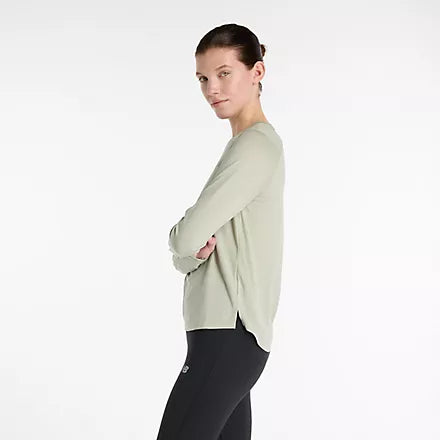 new balance athletics long sleeve, long sleeve breathable layering shirt, light green colour, side angle of woman wearing long sleeve new balance shirt with black leggings