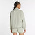 new balance athletics packable jacket for women, light wind breaker jacket that packs away into built in bag, light green colour, woman wearing nb jacket with matching shorts from behind