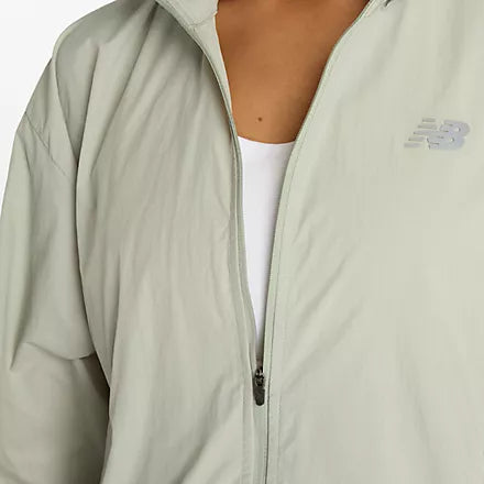 new balance athletics packable jacket for women, light wind breaker jacket that packs away into built in bag, light green colour, close up of zipper on nb jacket