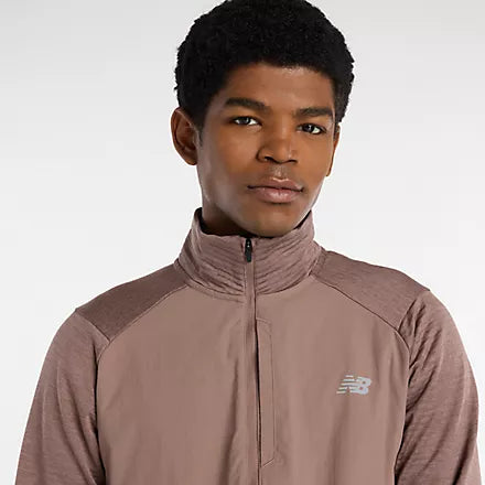 Man wearing new balance heat grid half zip run top in earth shadow colour