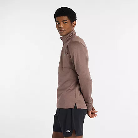 Man wearing new balance heat grid half zip run top in earth shadow colour, showing side