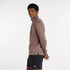 Man wearing new balance heat grid half zip run top in earth shadow colour, showing side