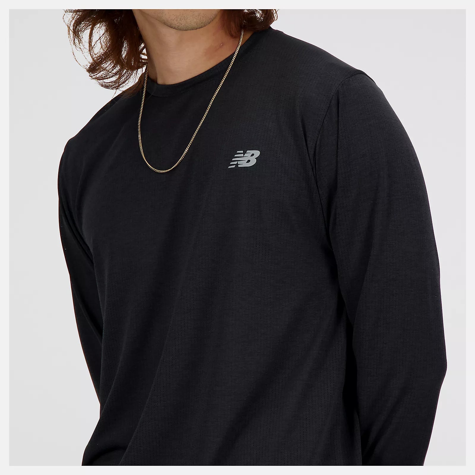nb athletics long sleeve shirt for men, breathable long sleeve shirt good for layering, black colour, close up of man wearing black nb long sleeve with silver nb logo