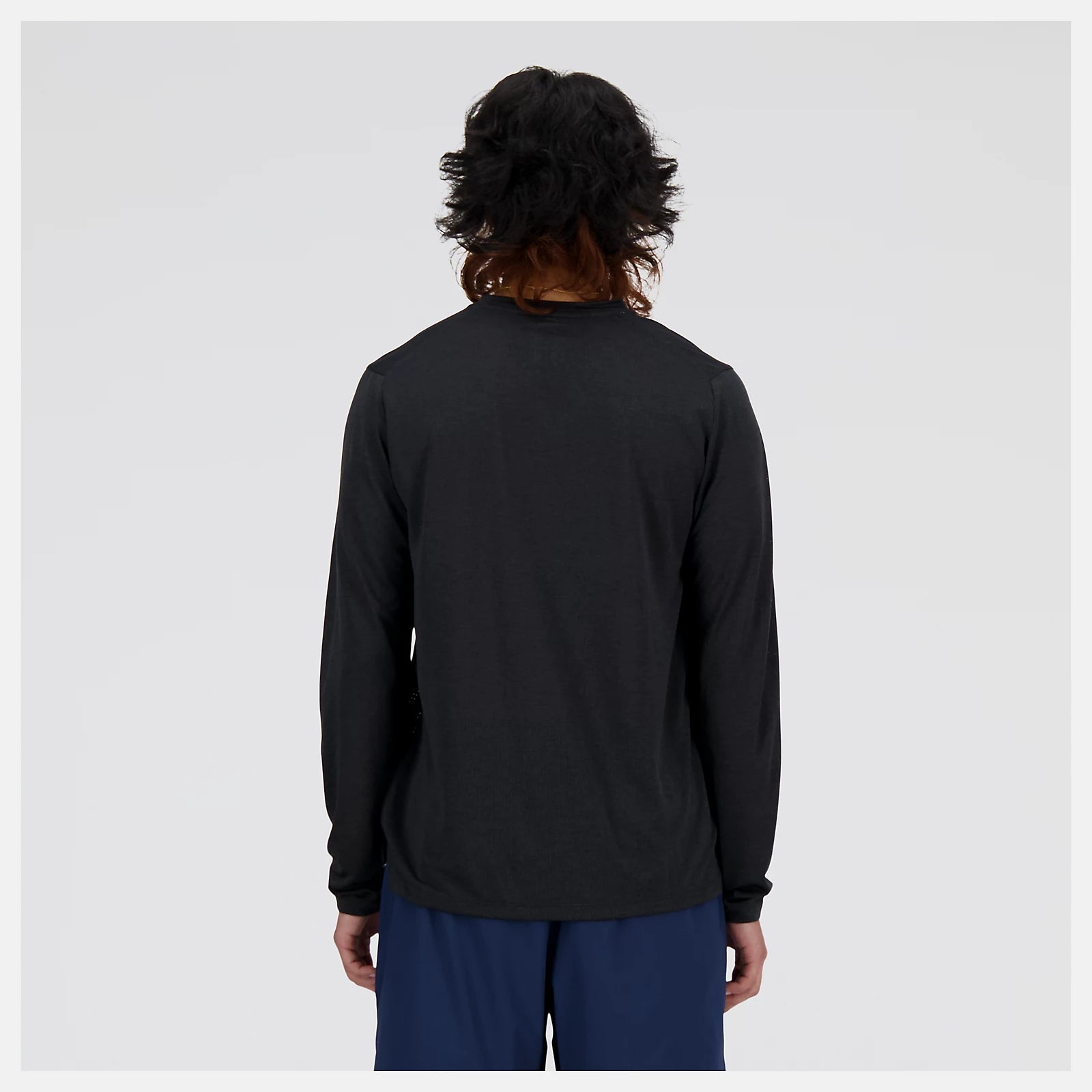 nb athletics long sleeve shirt for men, breathable long sleeve shirt good for layering, black colour, man wearing black nb long sleeve and navy shorts from behind