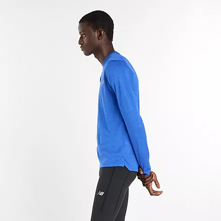 new balance athletics long sleeve shirt for men, lightweight breathable long sleeve top, royal blue colour, man turned to the side wearing long sleeve blue nb top with black tights