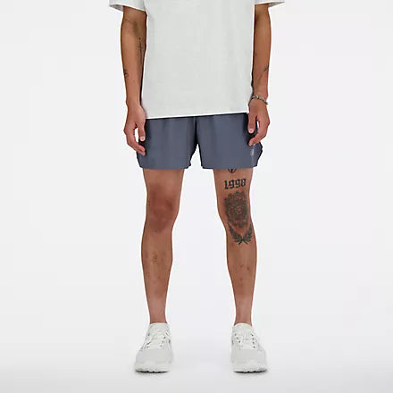 new balance rc short for men, lightweight 5in length running short for men, grey colour, male model chest down wearing grey nb shorts and white shirt with white shoes