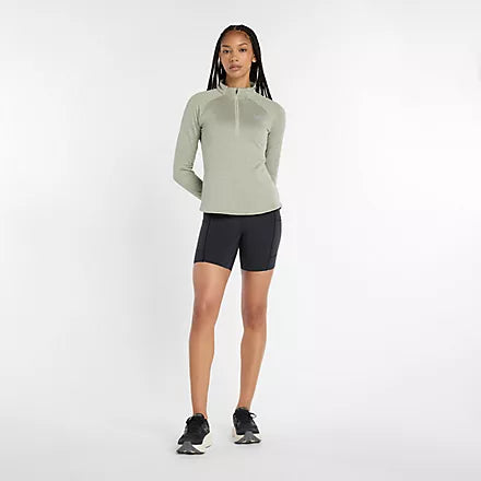new balance athletics heat grid half zip for women, warm half zip running jumper, light green colour, woman wearing new balance running half zip with black short tights and black new balance runners