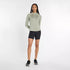 new balance athletics heat grid half zip for women, warm half zip running jumper, light green colour, woman wearing new balance running half zip with black short tights and black new balance runners