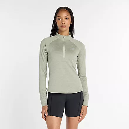 new balance athletics heat grid half zip for women, warm half zip running jumper, light green colour, woman wearing new balance running half zip with black short tights