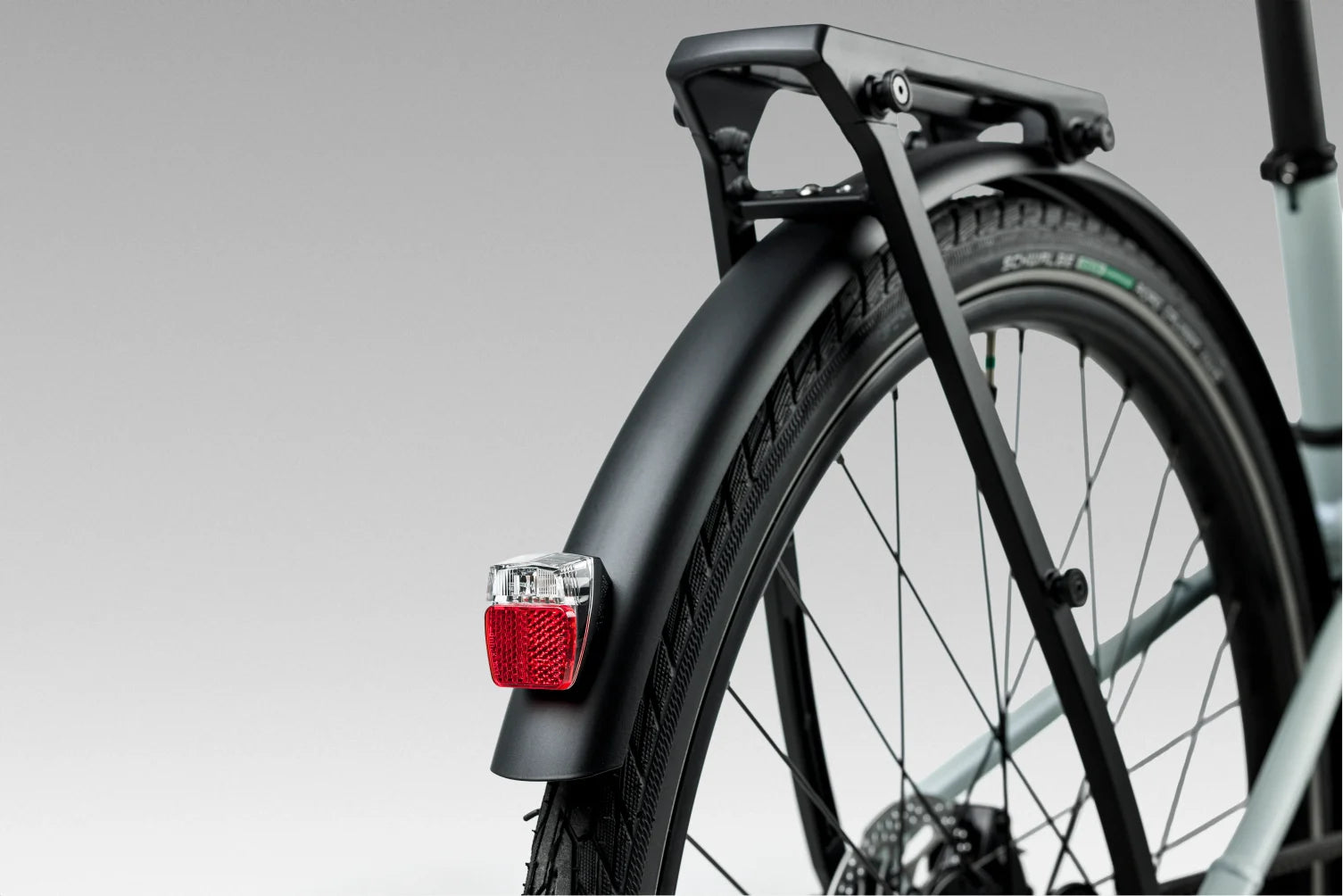 rear wheel of orbea vector with mudguards and pannier attached, also integrated bike light at rear