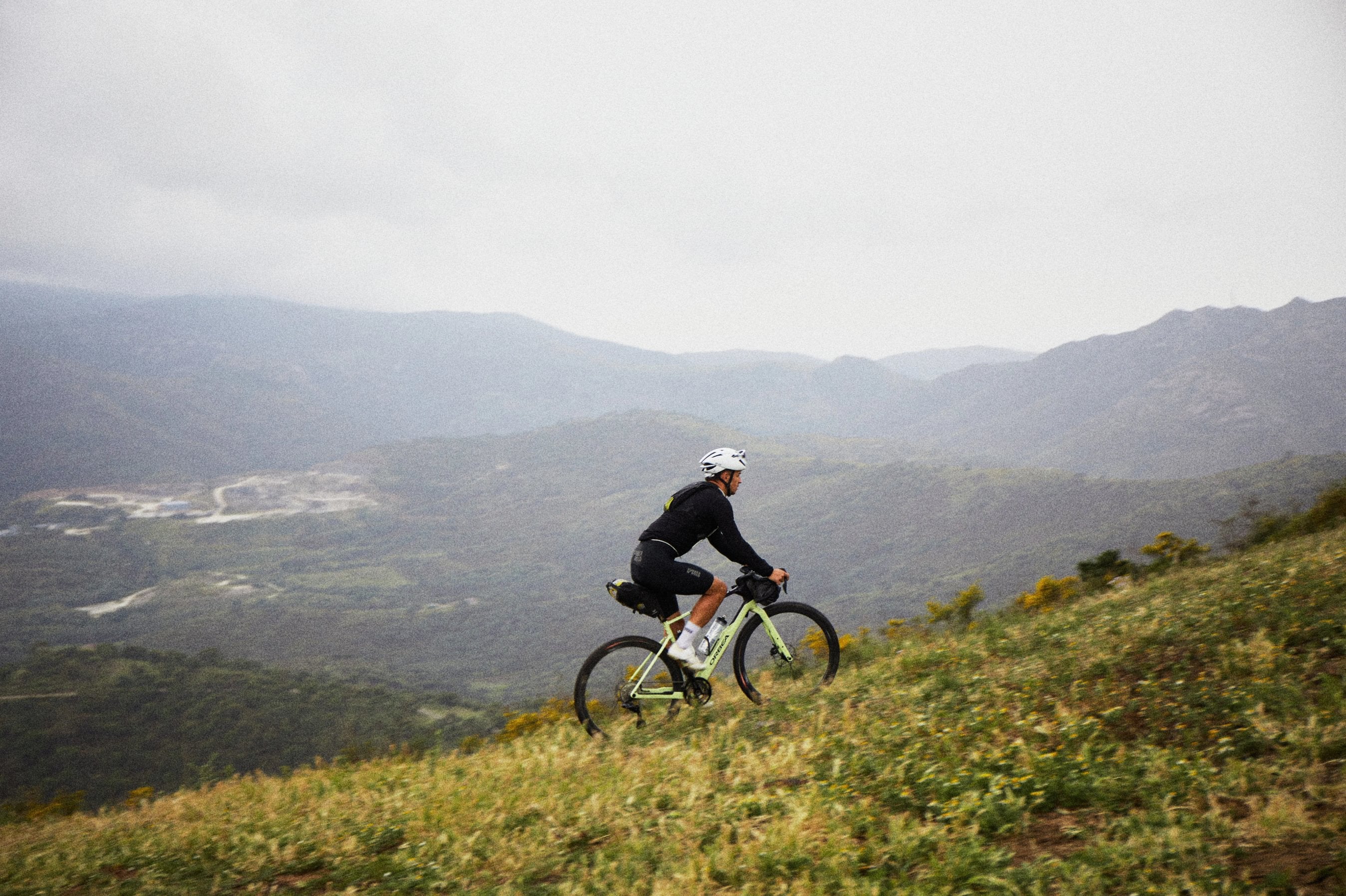 man cycling an orbea terra gravel bike in the mountains